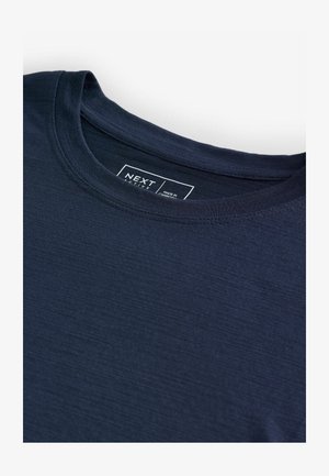 T-shirt à manches courtes bleu marine en tissu lisse avec un col rond. Présente une étiquette avec le texte "NEXT ACTIVE" au niveau du col.