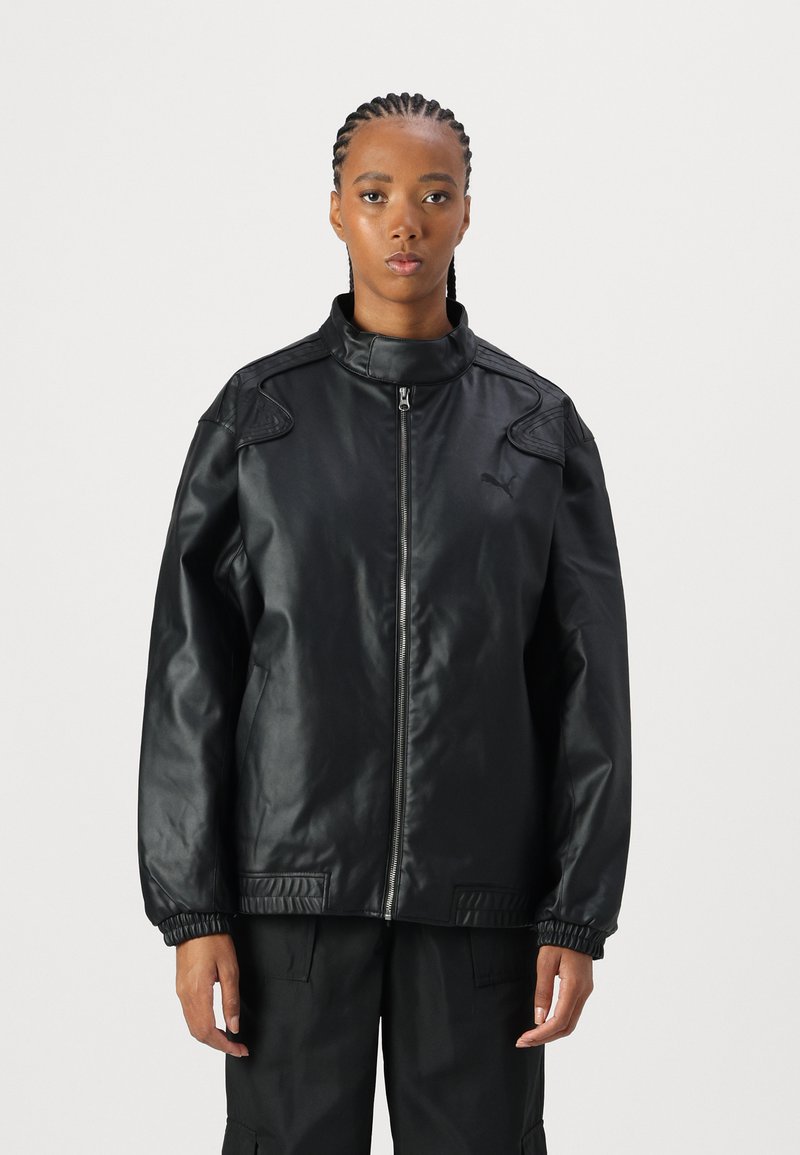 Veste en faux cuir noir avec un col haut, fermeture éclair et poignets côtelés. Présente des accents d'épaule et un logo discret.