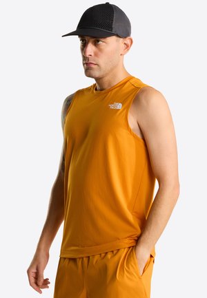 Top sportivo arancione senza maniche con una texture liscia, con un logo sul petto. Il modello indossa un cappellino nero in rete.