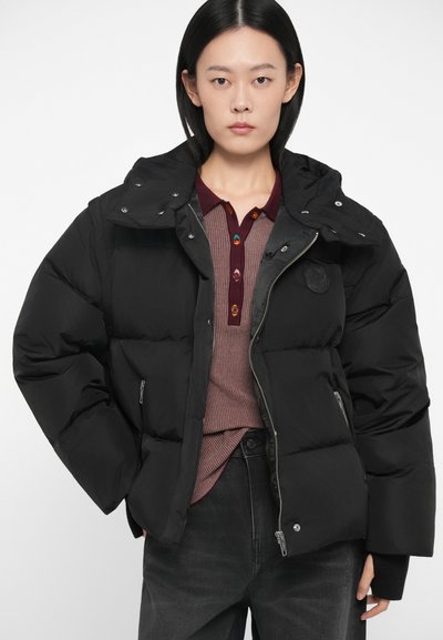 Μαύρη φουσκωτή τζάκετ με κουκούλα, με κλείσιμο φερμουάρ και κουμπιά σnap, κεντημένο μοτίβο και εντυπωσιακή ετικέτα με λογότυπο στο στήθος.