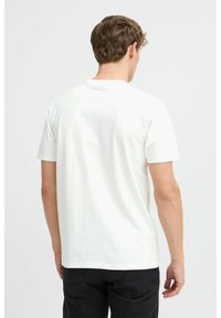 Hvid bomulds t-shirt med kortærmer og rund halsudskæring, glat tekstur og minimalistisk design. Bagfra ses ingen synlige mønstre eller logoer.