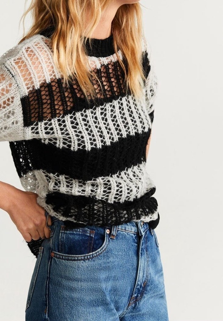 Top in maglia con motivo a righe bianche e nere, tessuto a trama aperta, maniche corte e scollatura rotonda, abbinato a jeans blu a vita alta.