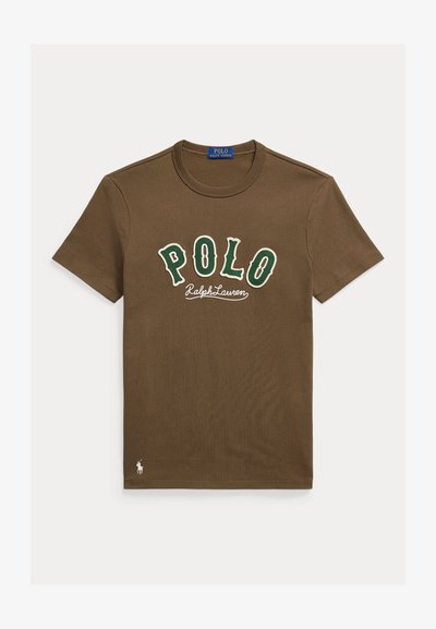 Rjava majica s kratkimi rokavi in okrolim izrezom z zelenimi črkami "POLO", belim napisom "Ralph Lauren" ter majhnim belim logotipom igralca polo na spodnji levi strani.