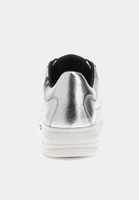 Baskets métalliques argentées avec semelle blanche, talon arrondi, texture lisse, col matelassé et accents noirs minimalistes.