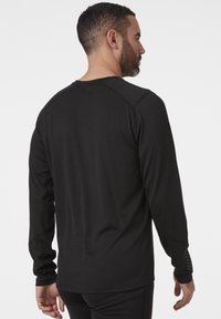 Zwart sportshirt met lange mouwen, gemaakt van textuurstof, met contrasterende schoudernaden en een slim fit ontwerp.