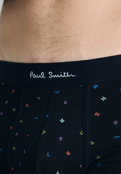 Črne bokserice z barvitim vzorcem črk, s priložno mehkega elastičnega pasu, ki prikazuje izvezeno ime blagovne znamke "Paul Smith."