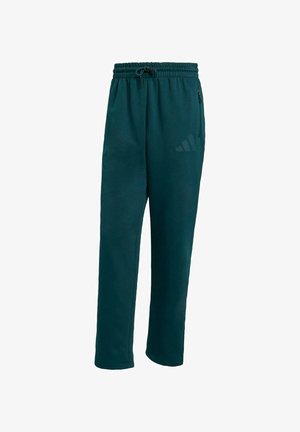 Tyrkysové športové nohavice vyrobené z mäkkej látky, s elastickým pásom, šnúrkou, bočnými vreckami a diskrétnym logom na nohe.