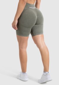 Oliwkowe szorty o wysokim stanie z teksturowanym wzorem i dopasowanym krojem; posiadają markowy pasek w talii i długość do kolan.