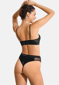 Ensemble de lingerie noir comprenant un soutien-gorge en résille avec des bretelles réglables et une culotte taille haute assortie, texture lisse avec des accents transparents.