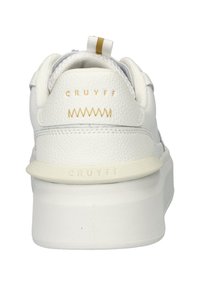 White leather sneaker with a textured finish, a rounded heel, gold accents, and branding on the heel and tongue. Light-colored sole.
