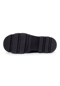 Semelle de chaussure en caoutchouc noir avec surface texturée et multiples rainures horizontales pour l'adhérence. Talon rond avec une légère courbure.