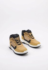 Botas de senderismo de media caña en tonos marrón y negro con cierre de cordones, paneles texturizados, suela de goma blanca y puntera reforzada.