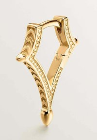 Gancho decorativo dorado con un diseño en forma de chevrón, superficie texturada, extremos puntiagudos y un mecanismo de cierre. Acabado suave con acentos brillantes.
