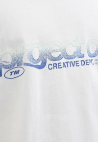 Weißes Baumwoll-T-Shirt mit dem verlaufenden blauen Text "project o" in einem verwitterten Effekt und "CREATIVE DEPT." in kleinerer Schrift darunter.