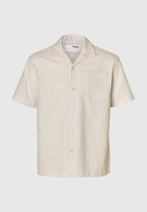 Lühikeste varrukatega kraega särk heledas kreemjas värvitoonis, millel on tekstuuriga ruuduline muster, rinnatasku ja heledad nööbid.