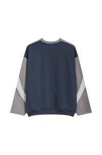 Krekliņš ar tumši zilu pamatni, pelēkiem piedurknēm un piparmētru zaļiem akcentiem. Mīksta tekstūra, apaļa kakla izgriezums un brīvs piegriezums.