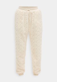 Φόρμες από φλις σε κρεμ χρώμα με σχέδιο πλεξίματος καναλιού, ελαστική μέση με κορδόνι και ελαστικά μανσέτες στους αστραγάλους.