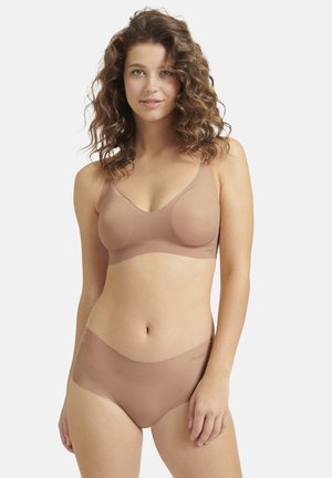 Set di lingerie seamless di colore nudo composto da un reggiseno morbido con spalline larghe e slip a vita alta coordinati, progettato per il massimo comfort.