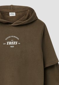 Bruine hoodie gemaakt van zachte stof, met witte tekst: "GOEDE MENSEN PLANTEN BOOMEN RED NU." Korte mouwen, minimalistisch ontwerp.