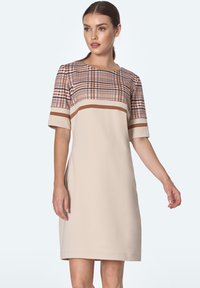 Beżowa sukienka z krótkim rękawem z górną częścią w kratę w ciepłych odcieniach, posiadająca poziome brązowe paski i prostą, klasyczną sylwetkę.