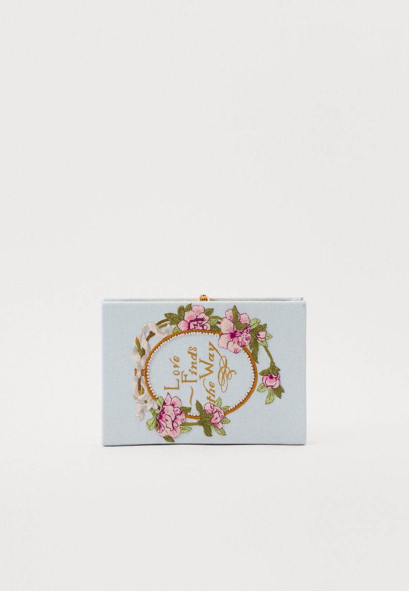 Mėlyna audinio rankinė su gėlių siuvinėjimu. Turi ovalią formą ir užrašą „Meilė randa kelią“. Uždarymas užsegamas sagtimi, paviršius lygus.