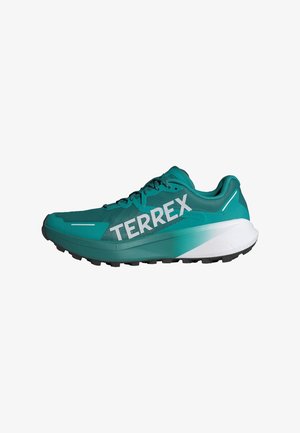 Turquoise athletic shoe with mesh upper, black sole, and prominent "TERREX" branding. Features a smooth white midsole and textured accents.