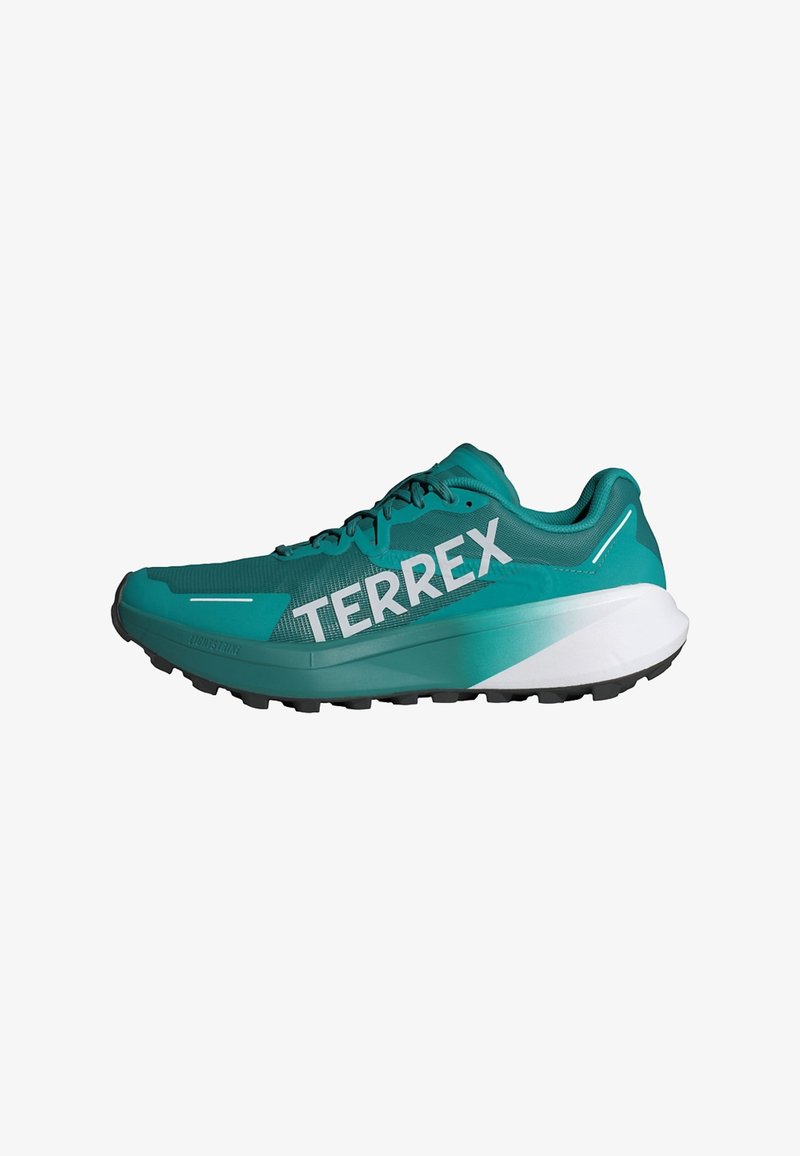Scarpa da atletica turchese con tomaia in rete, suola nera e branding "TERREX" ben visibile. Presenta una morbida intersuola bianca e dettagli texturizzati.