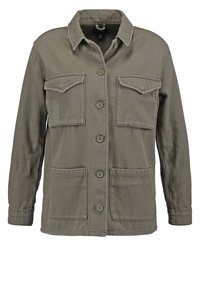 Olivgrön långärmad jacka i texturerat tyg. Har knappstängning, två bröstfickor och två nedre fickor, med fransiga kanter.