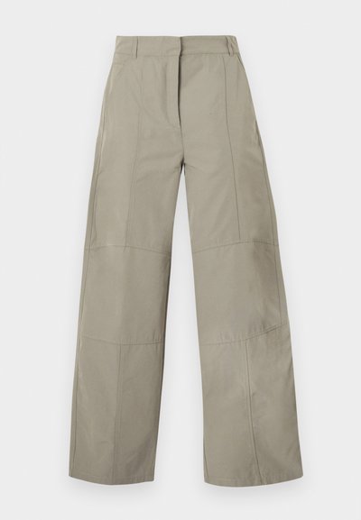 Pantalon beige à jambes larges avec taille haute, passants pour ceinture, détails de coutures frontales et fermeture avant cachée.