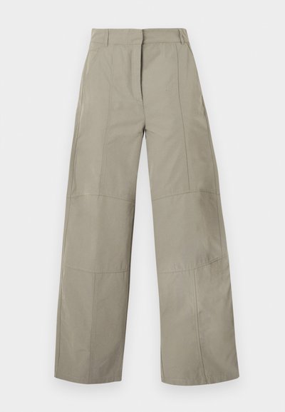 Pantalon beige à jambes larges avec taille haute, passants pour ceinture, détails de coutures frontales et fermeture avant cachée.