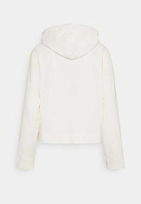Sudadera recortada en color blanco roto, fabricada con un tejido suave. Presenta una capucha y mangas raglán, con un diseño simple y sin costuras, y sin embellishments visibles.