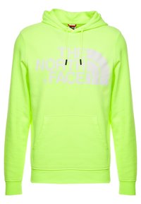 Neon grön hoodie gjord av mjukt tyg, med en framficka i kängurustil och en stor vit logga på bröstet samt svarta dragsnören.