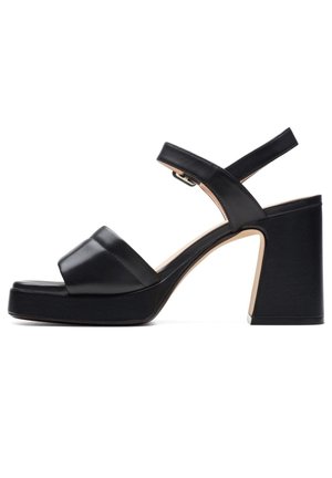 Sort læder platformsandal med brede stropper, justerbar ankelspænde og chunky høj blokhæl på hvid baggrund.