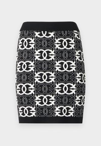 Saia preta e branca em malha com padrão geométrico abstrato, silhueta ajustada e cós preto canelado.