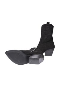 Stivali alla caviglia in suede nero con tacco quadrato e dettaglio con zip. La suola è strutturata con scanalature per una presa e stabilità ottimali.