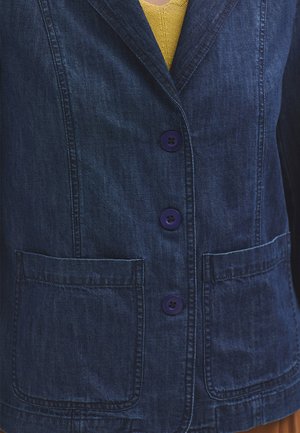 Denim jacket in dark blue, featuring three purple buttons, two front pockets, and a notched collar. Textured fabric visible.