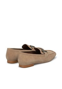 Mocassini in suede beige con suola piatta, caratterizzati da un accento decorativo in metallo sulla parte anteriore e foderati in modo liscio all'interno.