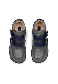 Graue Lederschuhe mit marineblauen Klettverschlüssen, runder Zehenform und einer weichen Wildleder-Oberfläche. Mit gesteppten Details und einem gepolsterten Innenraum.