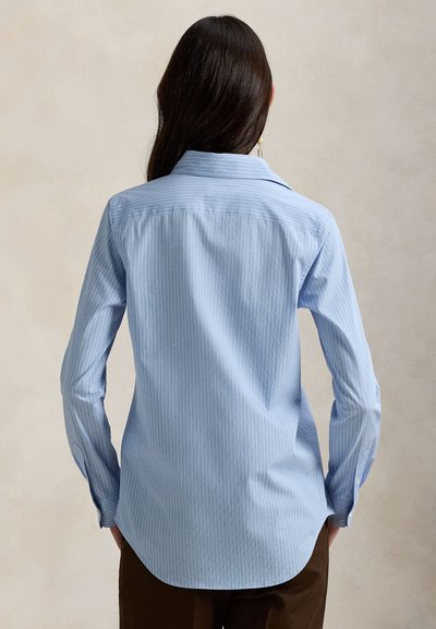 Ανοιχτό μπλε ριγέ πουκάμισο με μακριά μανίκια, γιακά με κουμπιά και καμπυλωτό τελείωμα. Κατασκευασμένο από λείο ύφασμα με διακριτική υφή.