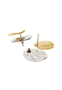 Złote i srebrne kolczyki o abstrakcyjnych kształtach, z dwoma wypolerowanymi wykończeniami metalowymi i teksturowaną powierzchnią, z widocznymi zapięciami i plecami kolczyków.