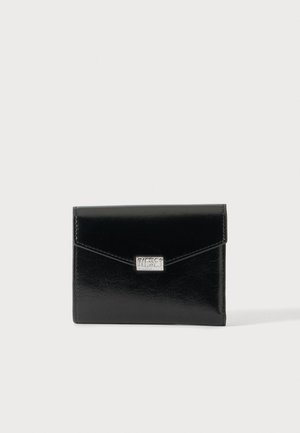 Portefeuille en cuir noir avec une plaque logo Diesel argentée sur le rabat avant sur un fond clair uni.