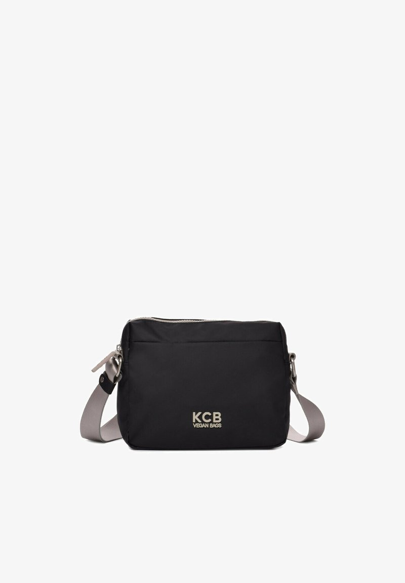 Bolsa vegana negra con una forma rectangular y elegante, que cuenta con un zipper plateado y una correa gris ajustable. Logo de KCB impreso en la parte frontal.