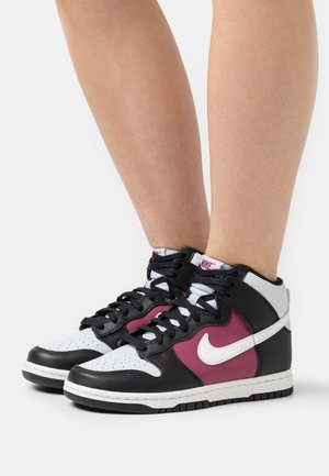 Hoge sneakers met zwart leer, witte accenten en kastanjebruine panelen. De neus heeft geperforeerde details, met een wit swoosh-logo.