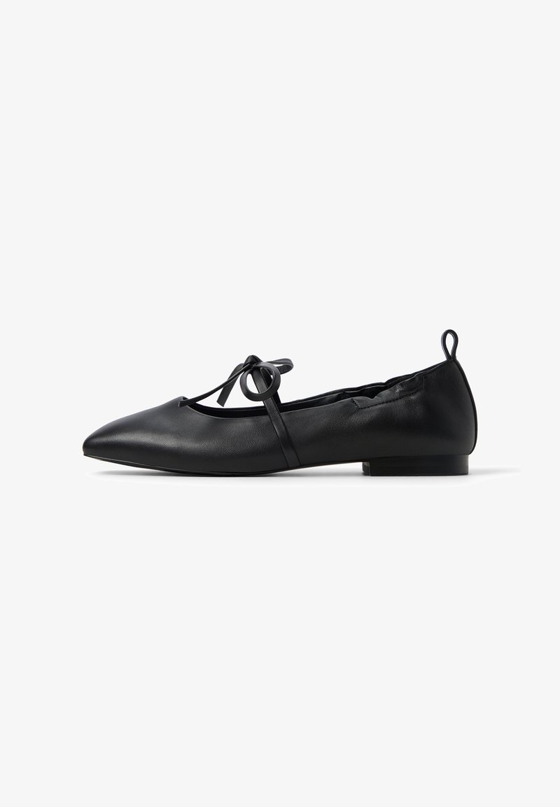Ballerine in pelle nera con punta affilata, dotate di una cinghia decorativa alla caviglia con un anello, tacco basso e superficie liscia.
