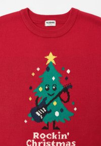 Roter Pullover mit einem Weihnachtsbaum-Motiv, das eine Gitarre zeigt, geschmückt mit bunten Ornamenten und einem Stern auf der Spitze. Text: "Rockin' Christmas."
