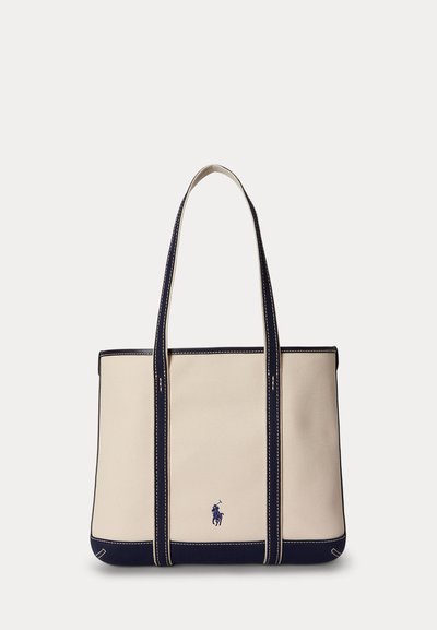 Beige canvas tote bag with navy blue trim, double shoulder straps, and a small navy embroidered horse and rider logo at the front center.