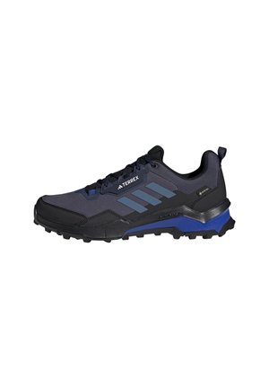 Zapatillas de trail en negro y azul marino con una parte superior de malla, superposiciones texturizadas, diseño de tres rayas en azul y suela de goma robusta para tracción.