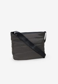 Bolso bandolera acolchado gris con una correa negra, que presenta un cierre de cremallera y detalles de costura sutiles. Textura suave y forma rectangular.