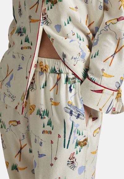 Conjunto de pijama de algodón con fondo crema, que presenta patrones coloridos de actividades al aire libre, ribete rojo en el cuello y los puños, y cintura elástica.