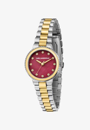 Orologio rotondo con quadrante color bordeaux, lunetta con accenti dorati, cinturino in metallo argentato e dorato, e indicatori delle ore con cristalli. Nome del marchio visibile.